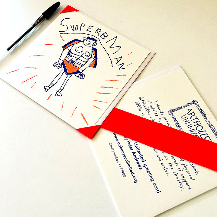 A white greetings card with a hand drawn picture of a man in blue and orange with the words Superb Man 
