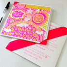 A bright pink, orange and yellow card with positive messages including the words take it easy