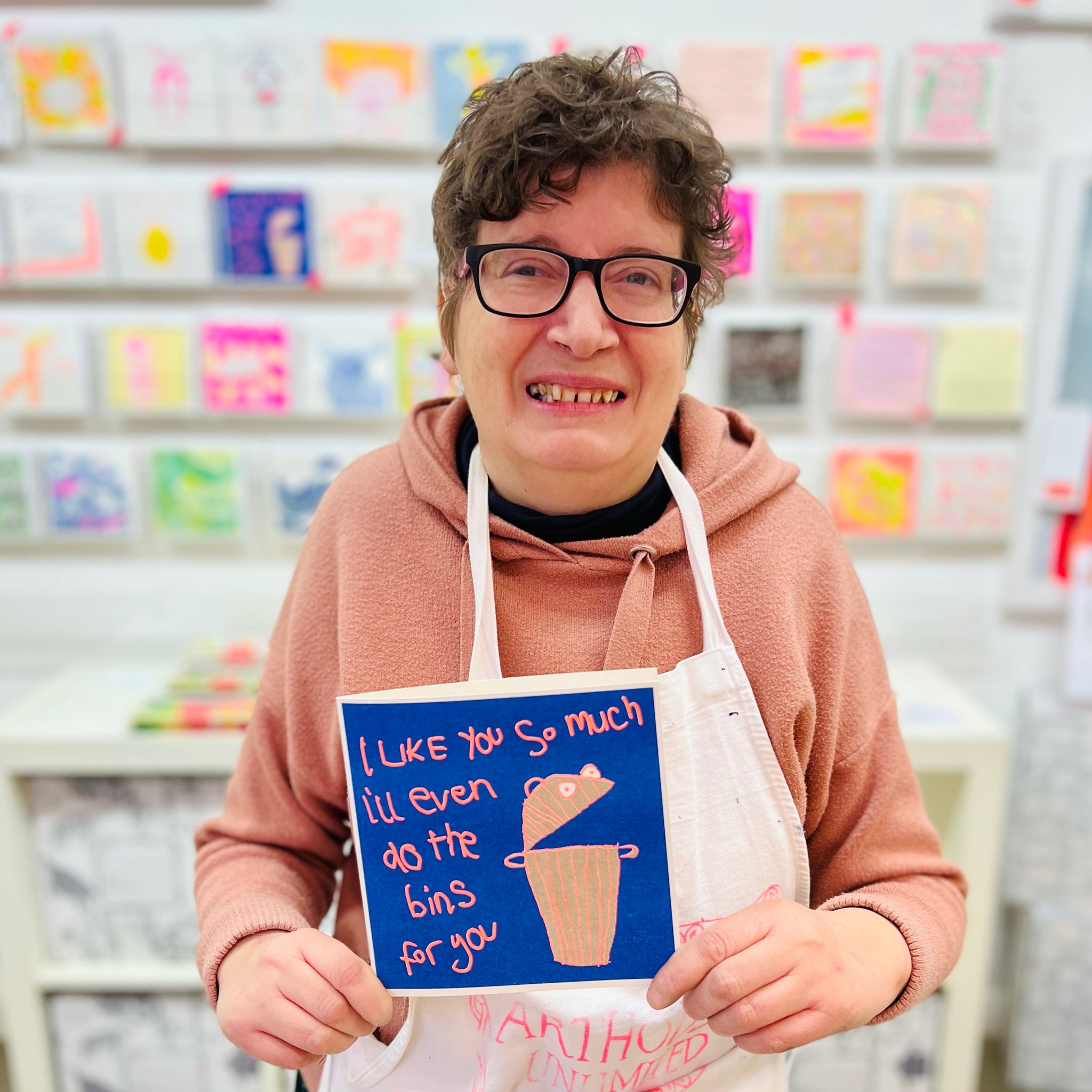 A female artist holding A blue and orange drawing of a bin and the words I like you so much I'll even do the bin for you