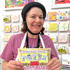 Artist holding Blue Dogs, Milk Chocolate Bar Cheesecake with Gingernut Crunch, blue and yellow packaging