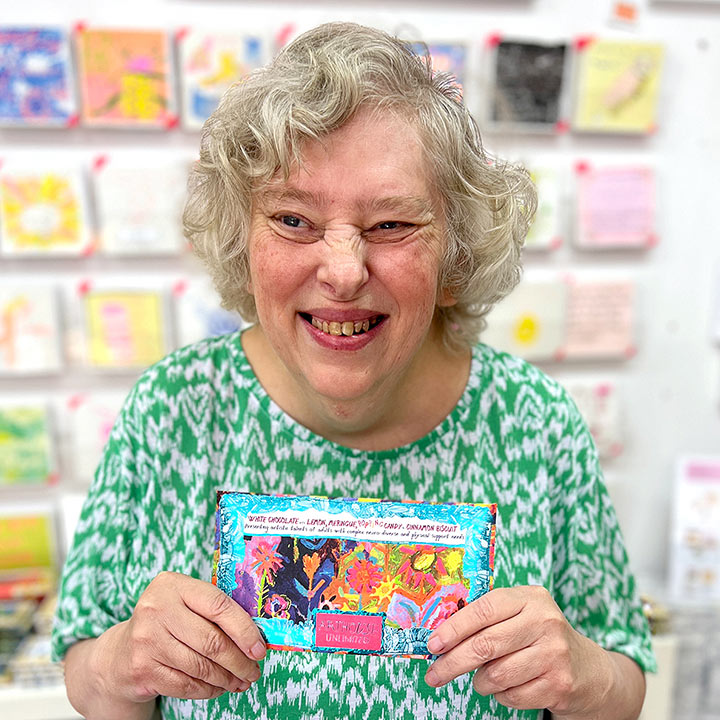 Female artist holding Sunflowers in the Hills, White Chocolate Bar with Lemon Meringue, Popping Candy & Cinnamon Biscuit Crunch