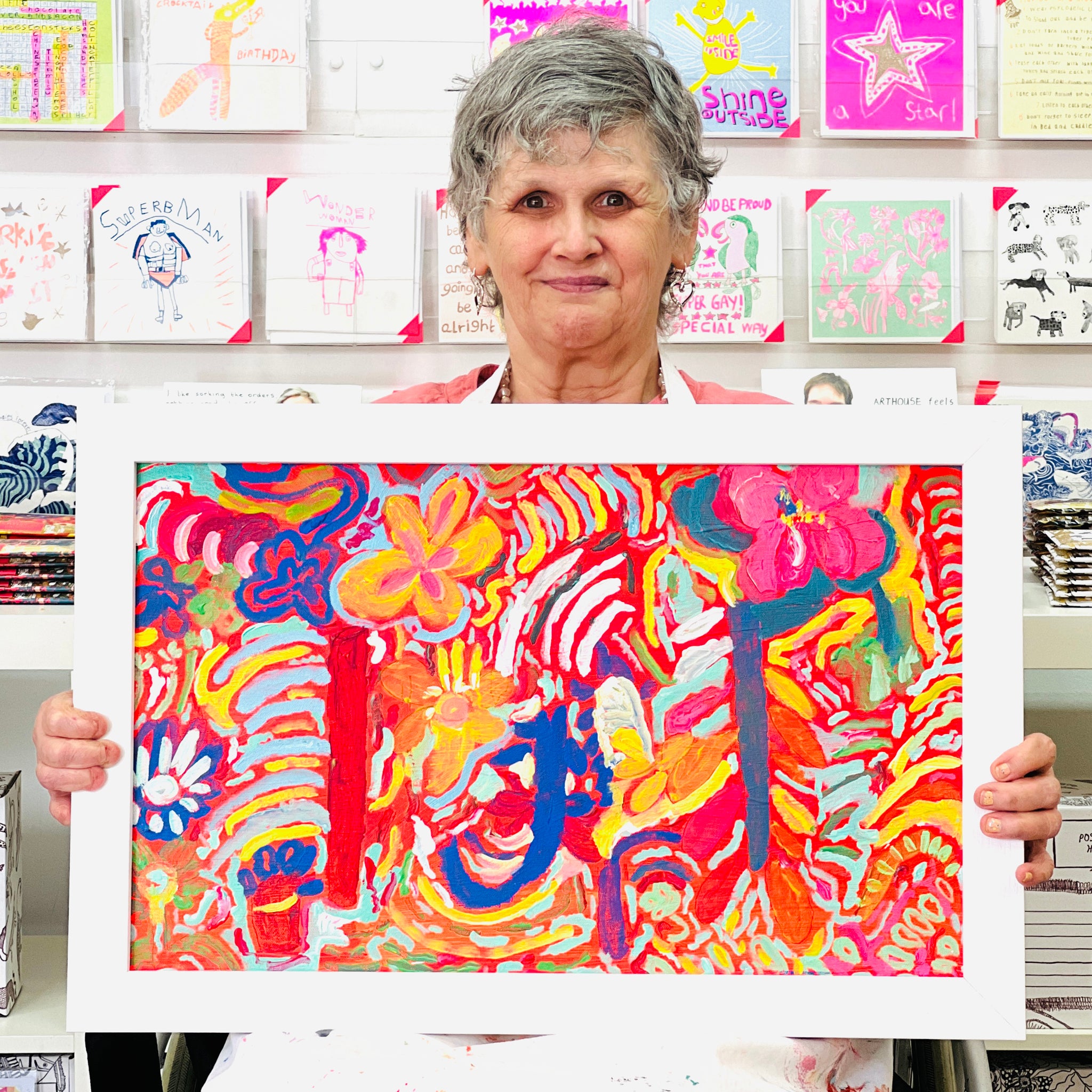 Female artist holding Framed colourful abstract artwork called Colourful Garden