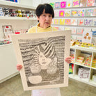 Female artist holding Hand drawn picture in pencil of a woman at the hairdressers