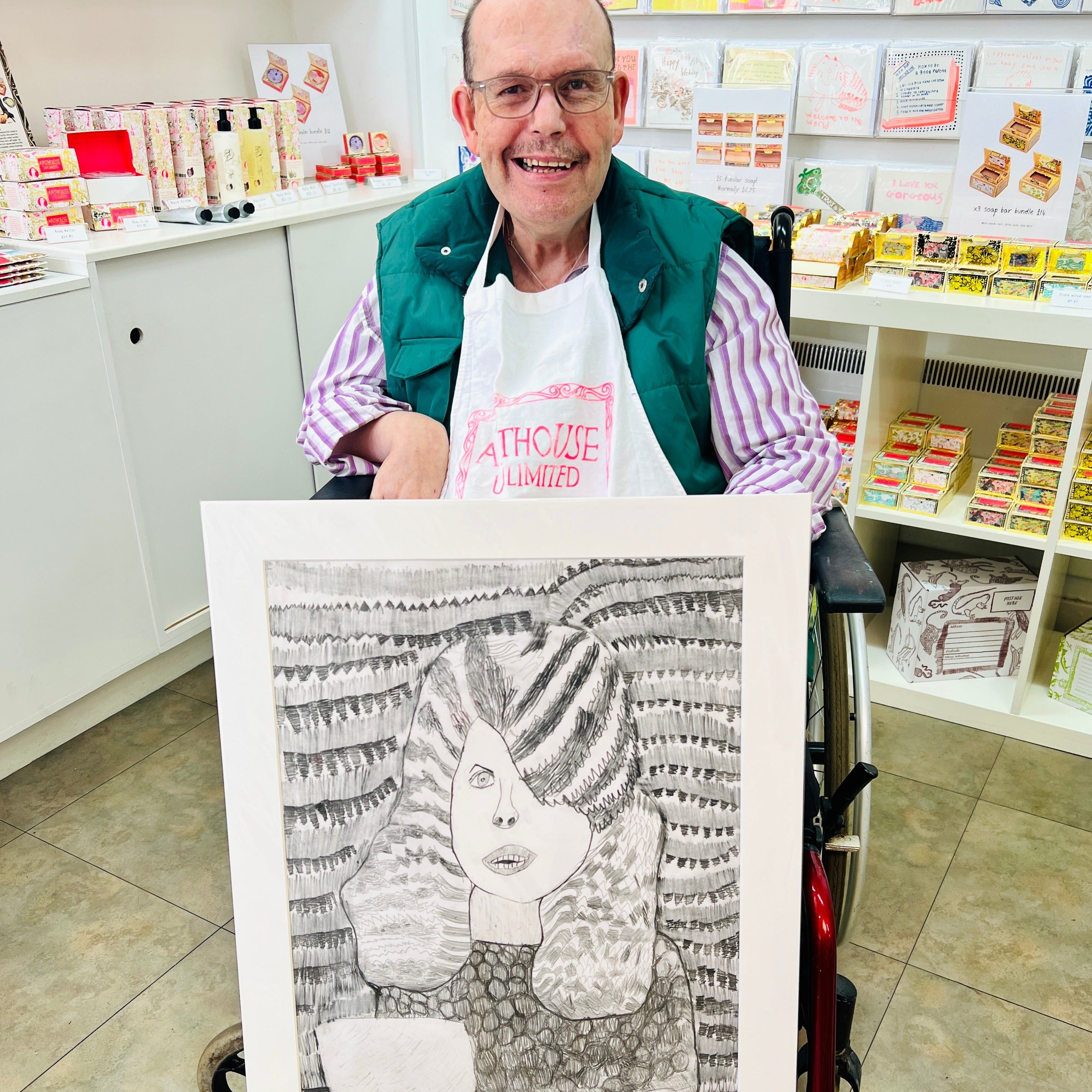 Male artist holding Hand drawn picture in pencil of a woman at the hairdressers