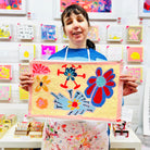 Female artist holding Framed painting of flowers in blues, purples and yellow
