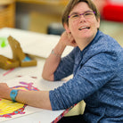 Female artist drawing bright coloured birds in a studio