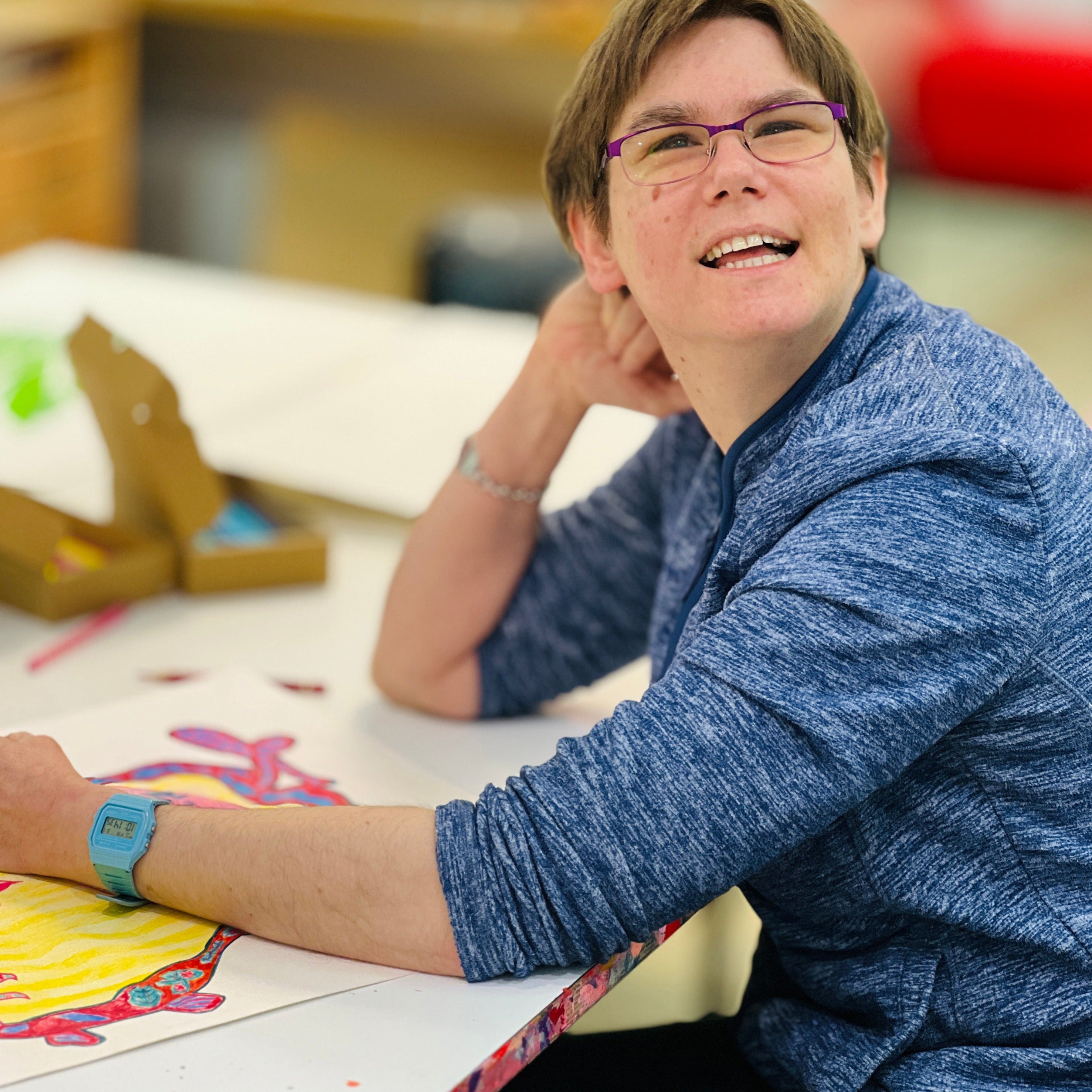 Female artist drawing bright coloured birds in a studio