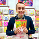 Male artist holding packet of carrot seeds