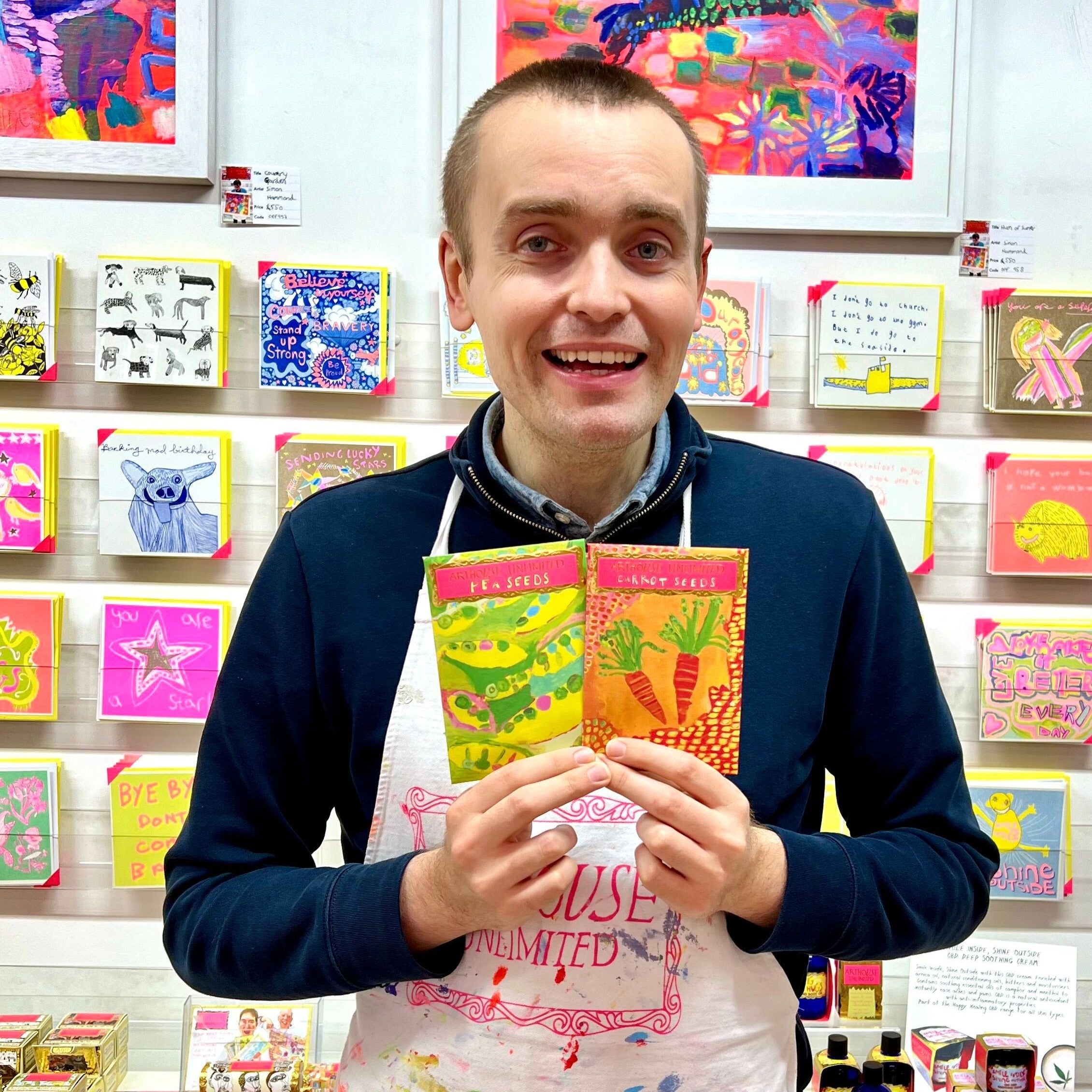 Male artist holding packet of carrot seeds