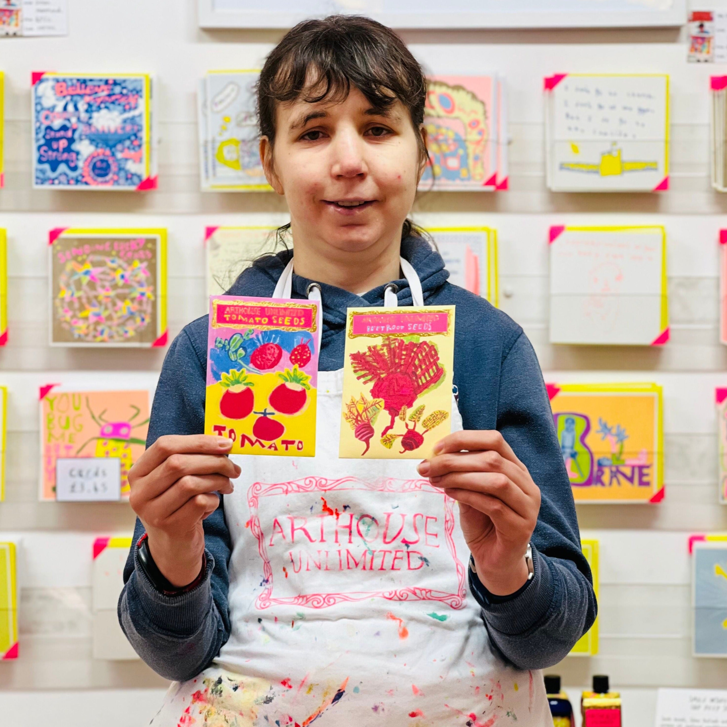 Female artist holding packet of beetroot seeds