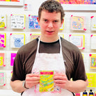 Male artist holding bright coloured Pea Seeds in greens and pinks