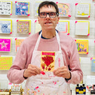 Male artist holding Red and green packet of Beetroot Seeds