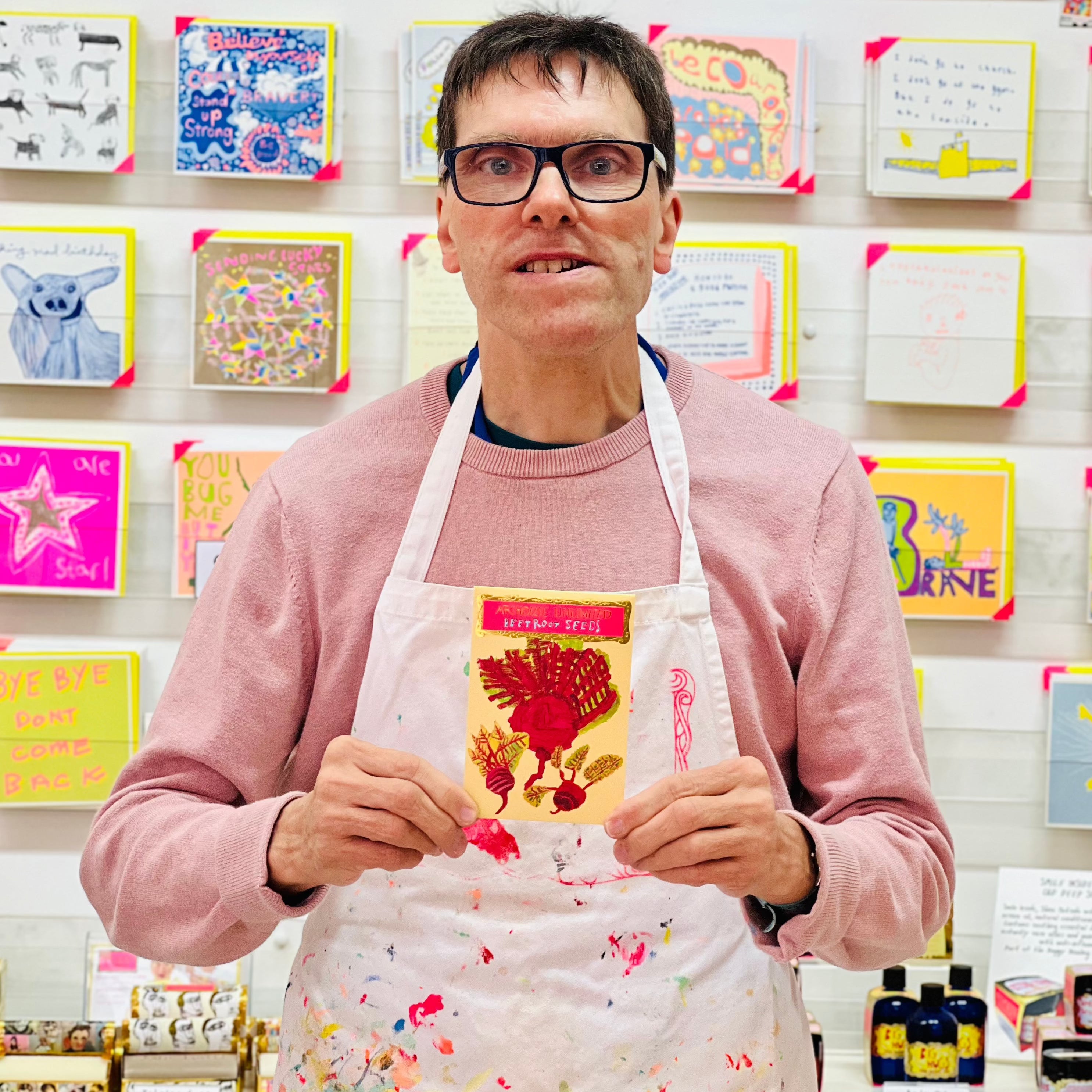 Male artist holding Red and green packet of Beetroot Seeds