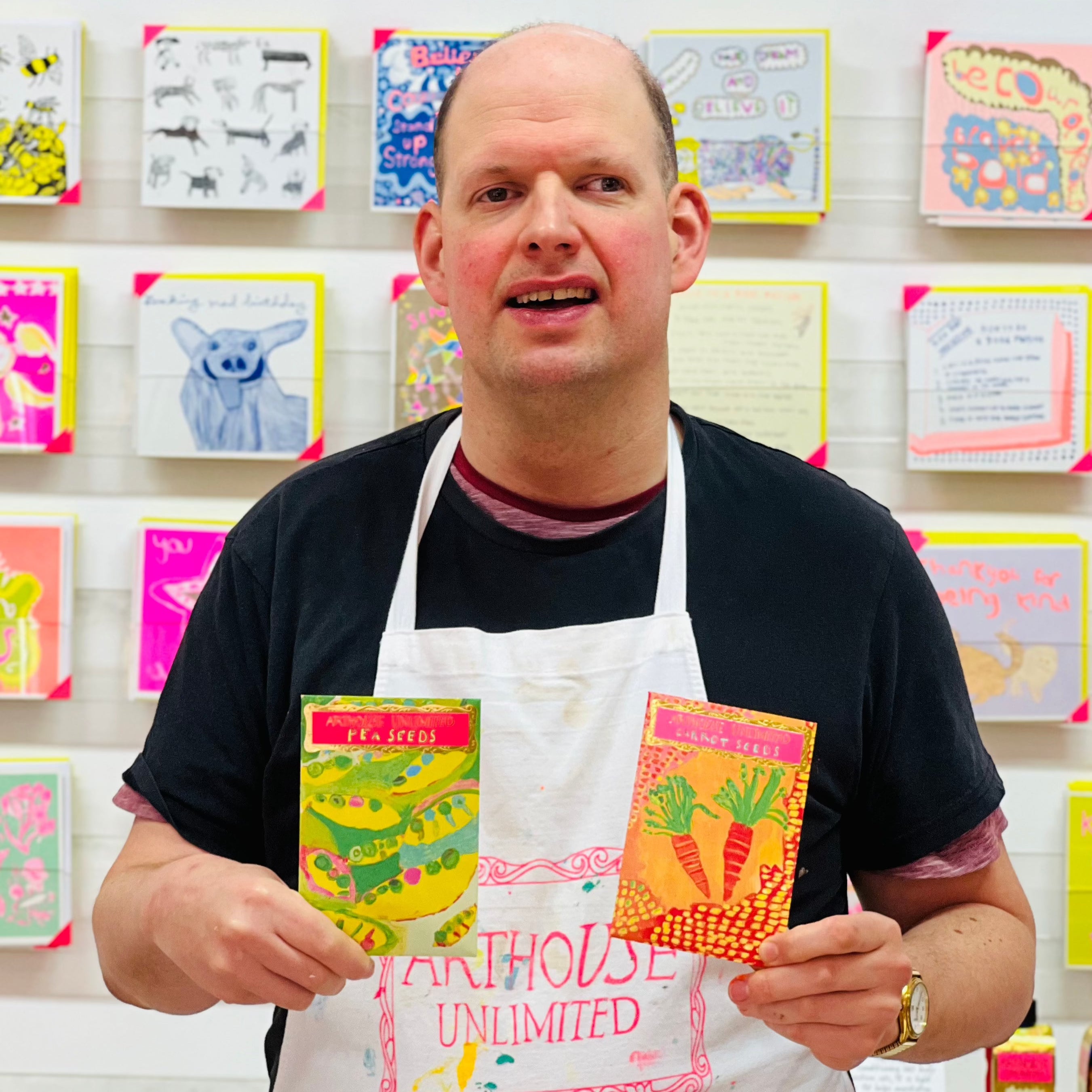 Male artist holding bright coloured Pea Seeds in greens and pinks