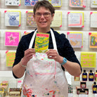 Female artist holding bright coloured Pea Seeds in greens and pinks