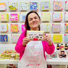 Female artist holding Black, pink and gold packet of Dogalicious, Milk Chocolate Bar with Honeycomb