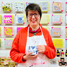 Female artist holding Blue Dogs, Fine Bone China Mug with dog drawings 