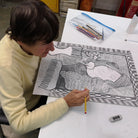 Female artist in a studio drawing a woman in pencil 