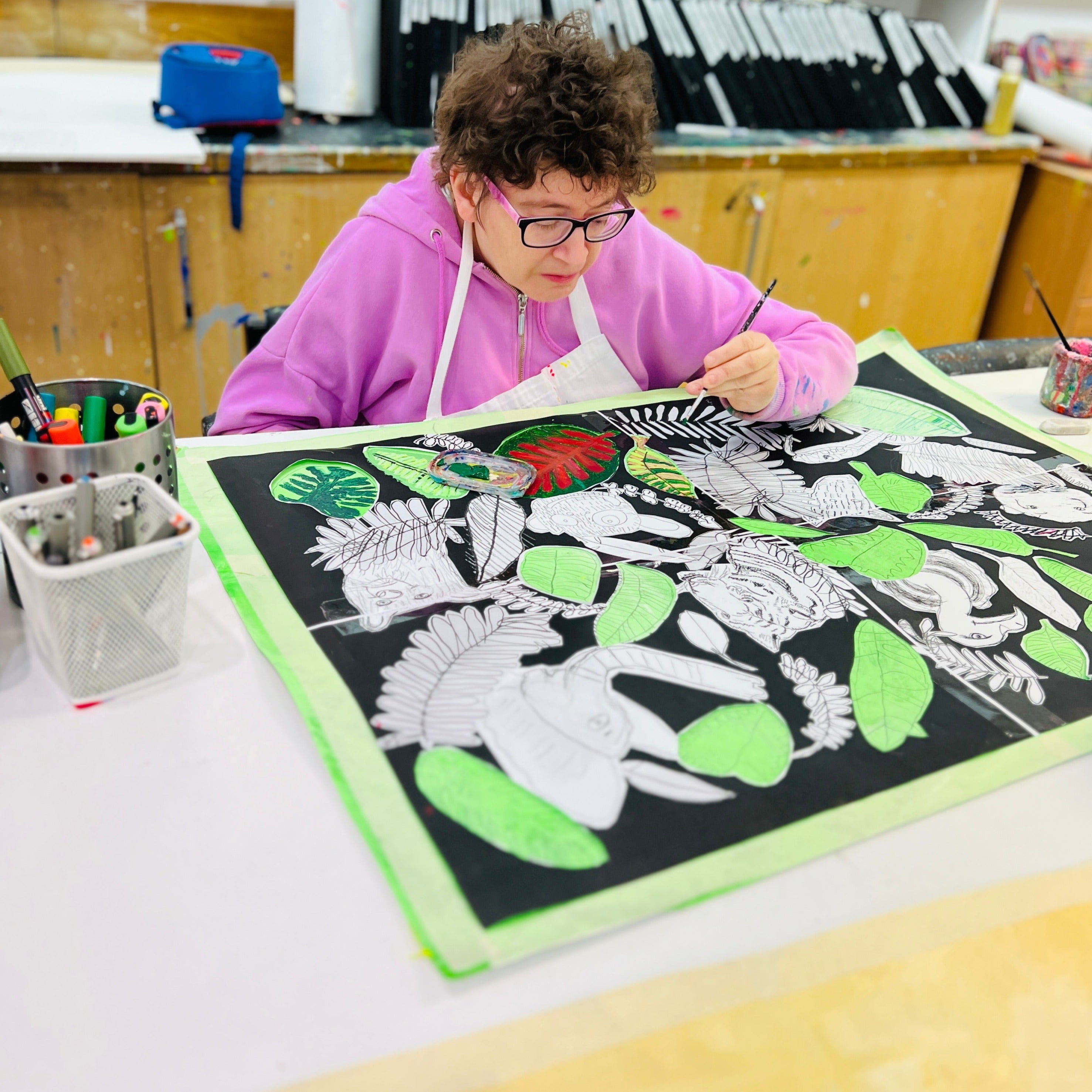 Female artist painting leaves on a jungle book painting 