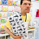 Male artist holding Dogalicious, 100% Organic Cotton Tea Towel with black dogs
