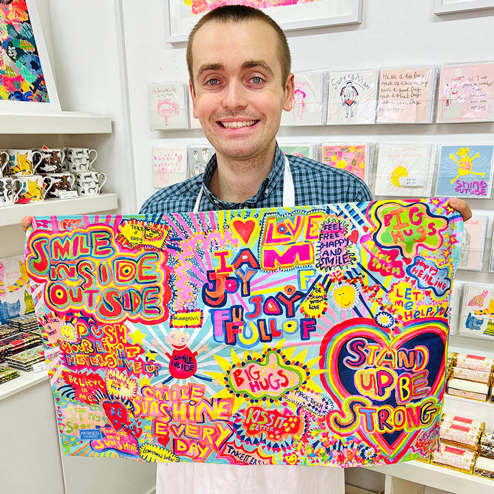 Male artist holding bright coloured Full of Joy, 100% Organic Cotton Tea Towel