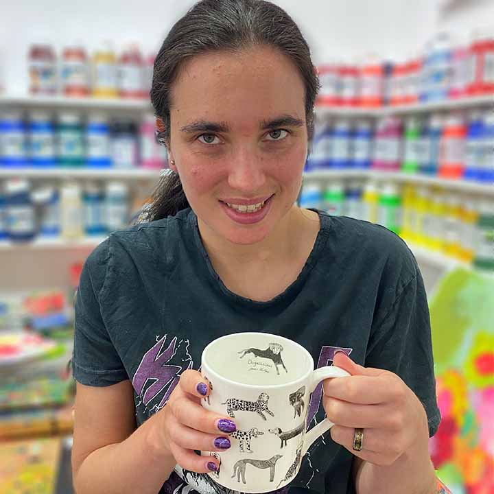 Artist holding Dogalicious, Fine Bone China Mug with black dog drawings