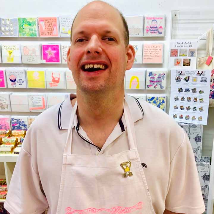 Male artist wearing A pin badge featuring a wheelchair user with the words 'I can" in white and yellow