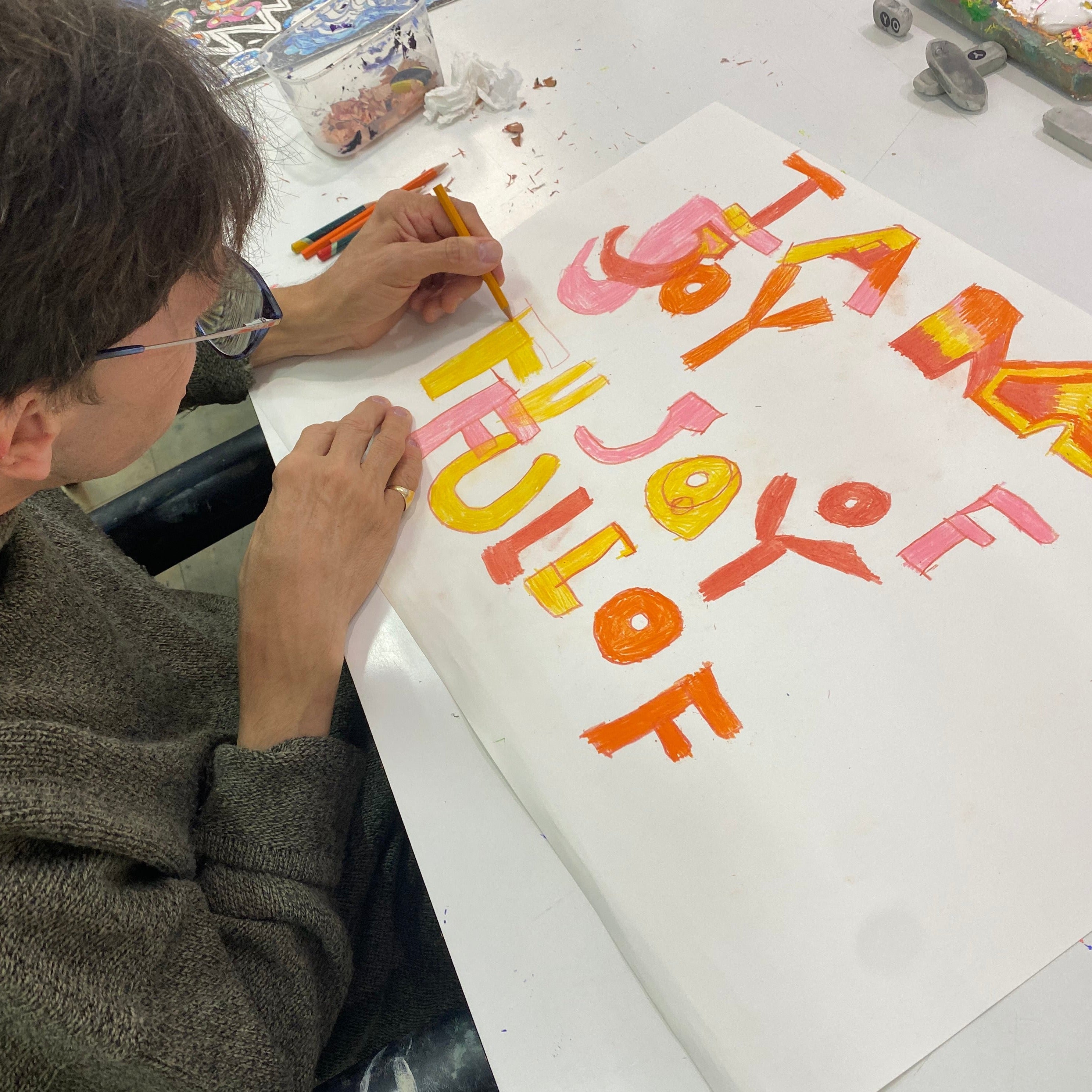 Artist Simon drawing original artwork in orange and yellow