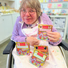 Female artist holding serval packets of arthouse unlimited packets of chocolate buttons 