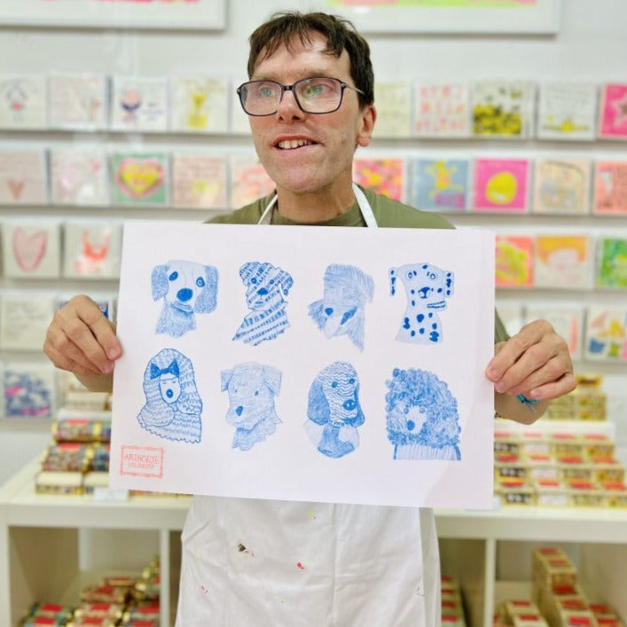 Male artist holding Blue Dogs, Riso Print