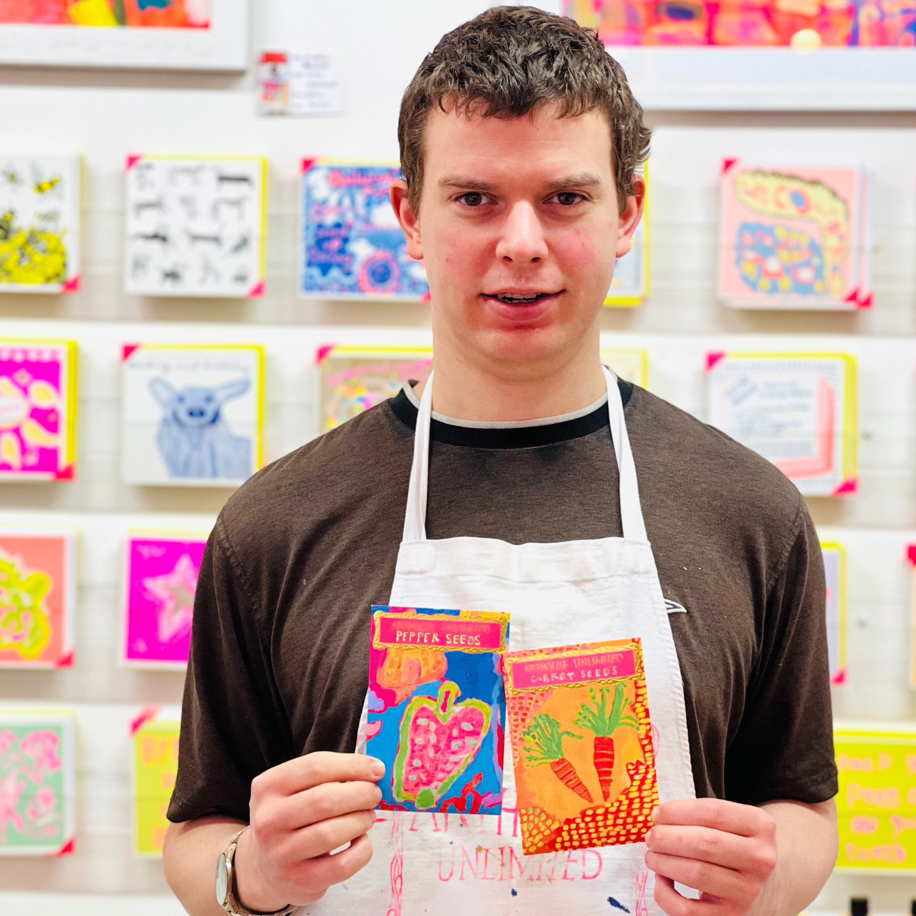 Male artist holding Bright coloured packet of Red Pepper Seeds