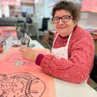 Female artist drawing a tiger on orange paper