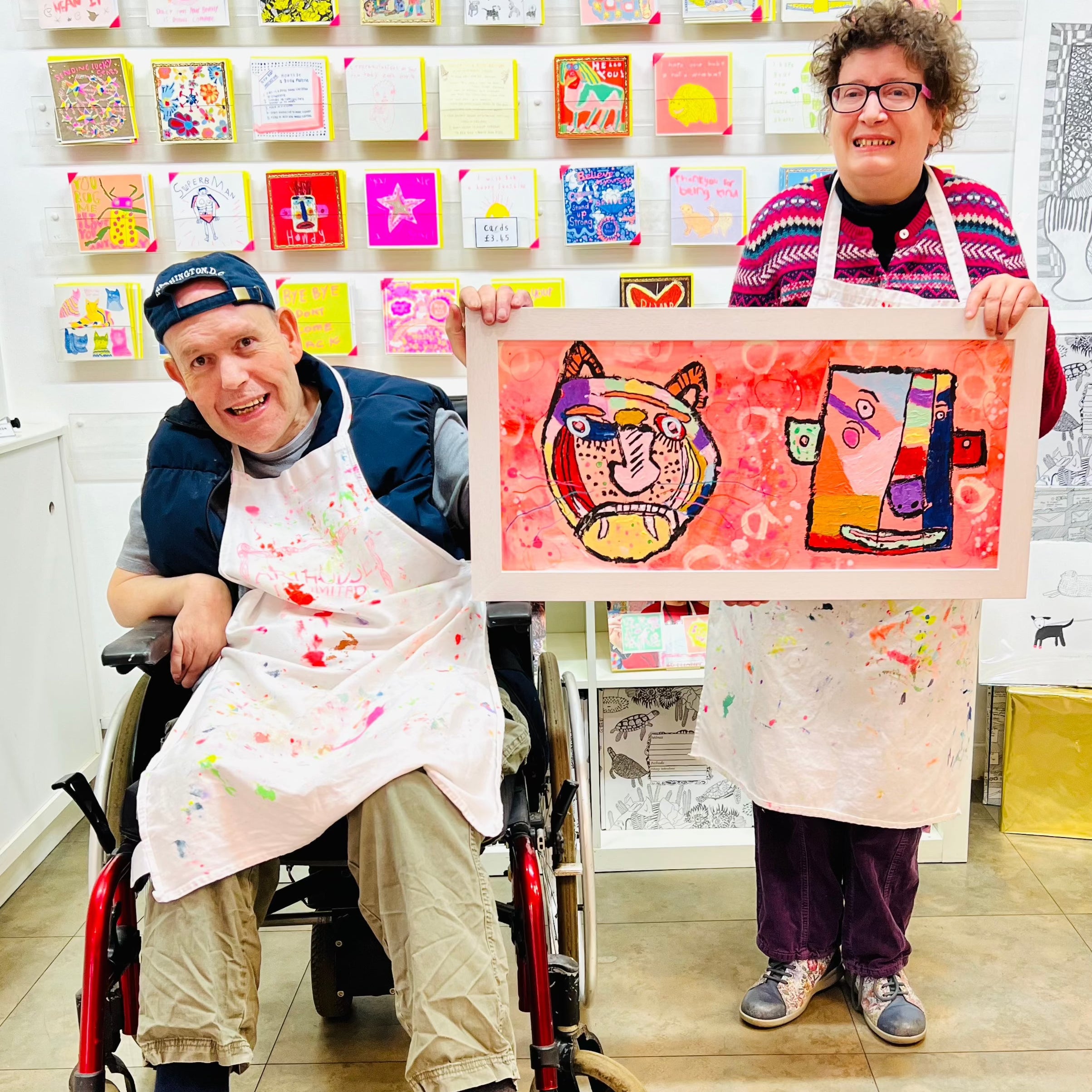 Male and female artist holding Framed painting of a colourful abstract tiger and a man 