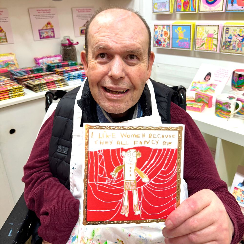 Artist Peter Andrews holds his card that he designed.