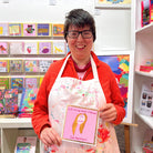Artist Maria Travis holding the Madonna greeting card that she designed.