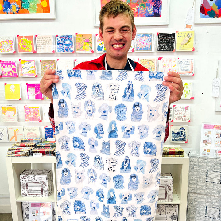 Male artist holding Blue Dogs, 100% Organic Tea Towel